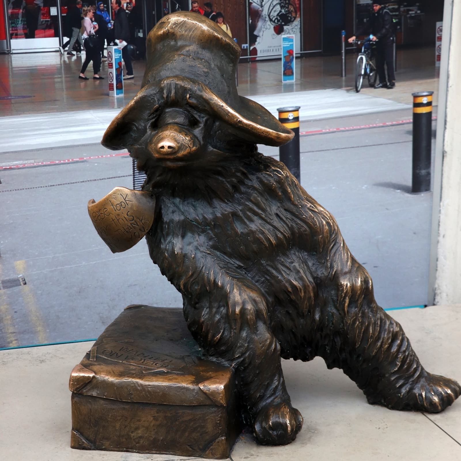 The bronze Paddington Bear statue sitting on its suitcase inside Paddington station