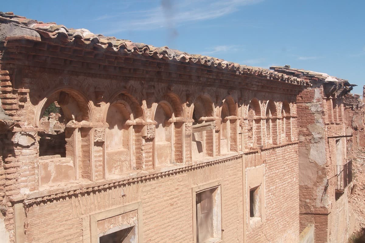 Ruined red-brick arcaded wall with empty windows in Belchite old town