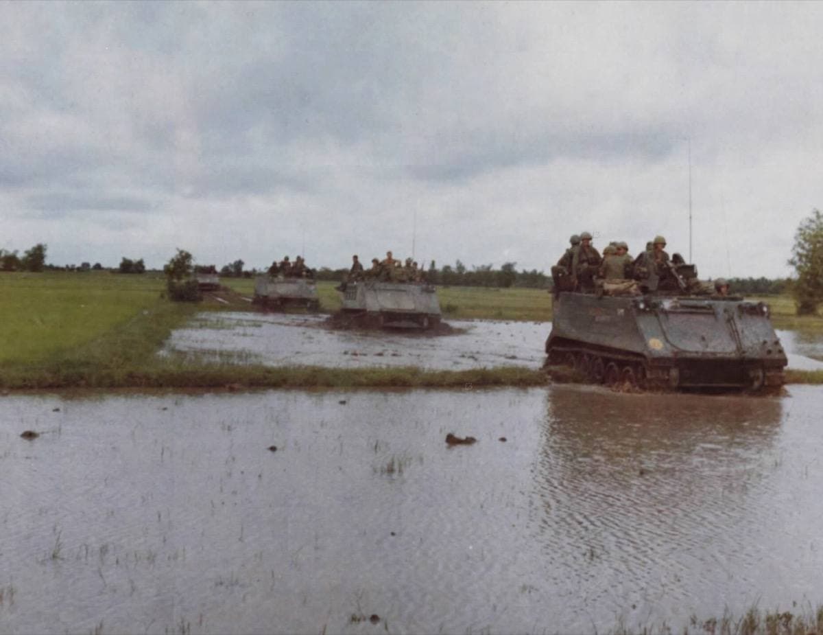 Armoured carriers crossing flooded rice paddies in a line