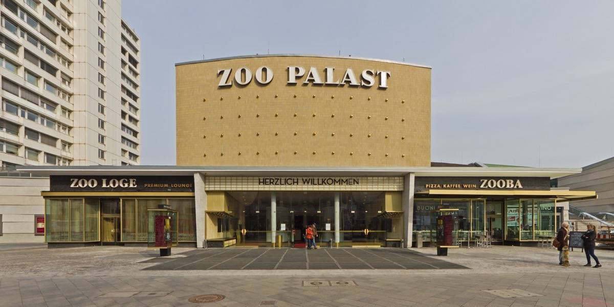 The long lit front of the Zoo Palast cinema at dusk