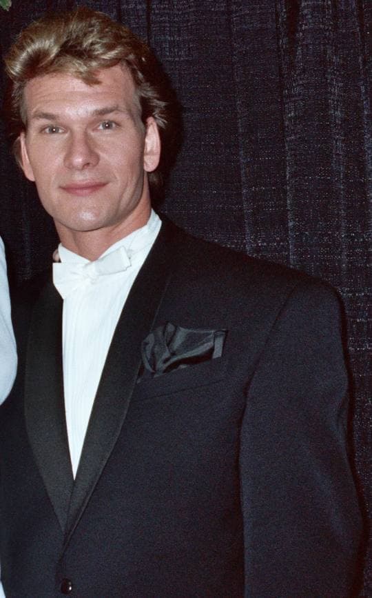 Patrick Swayze in a dinner jacket and white bow tie, smiling slightly