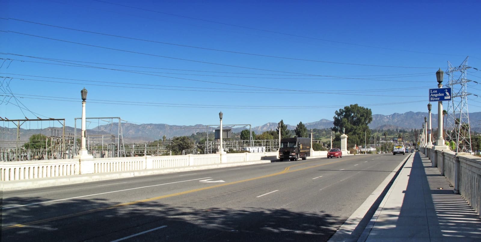 A road bridge with lamp posts, mountains beyond