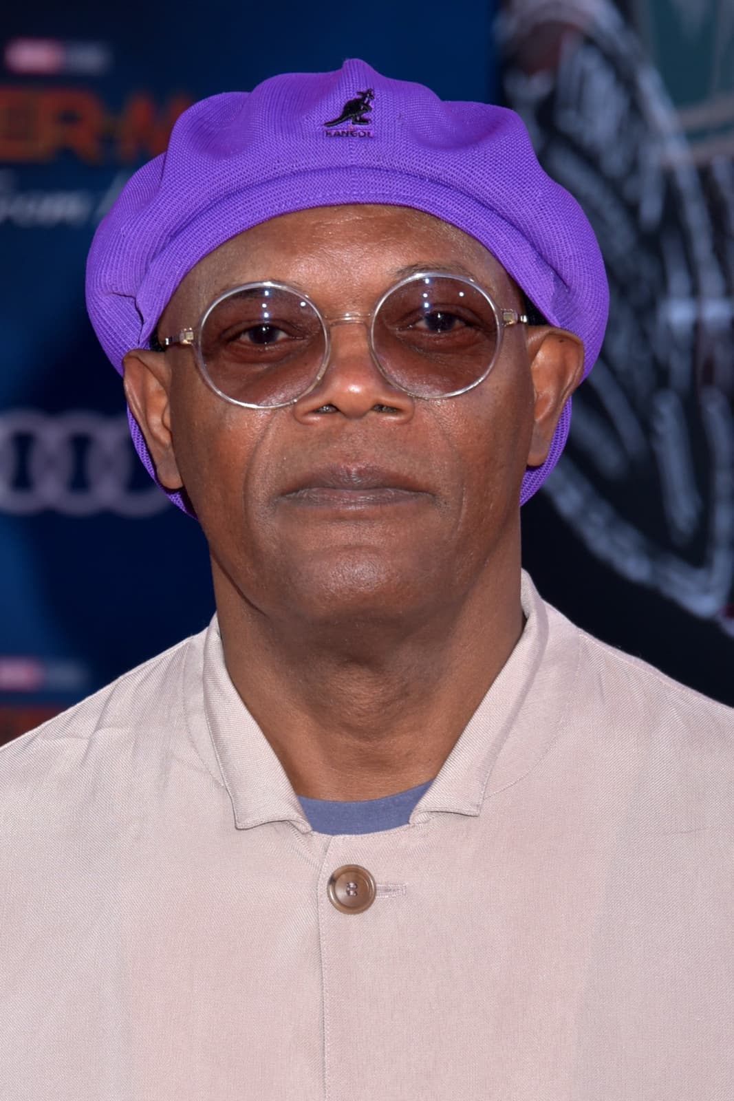 Samuel L. Jackson in a purple Kangol cap and round glasses