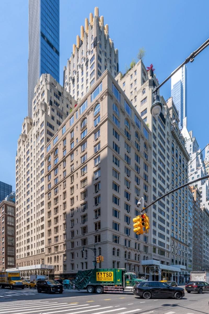 A tall pale tower with a gilded crown on a corner of Central Park South