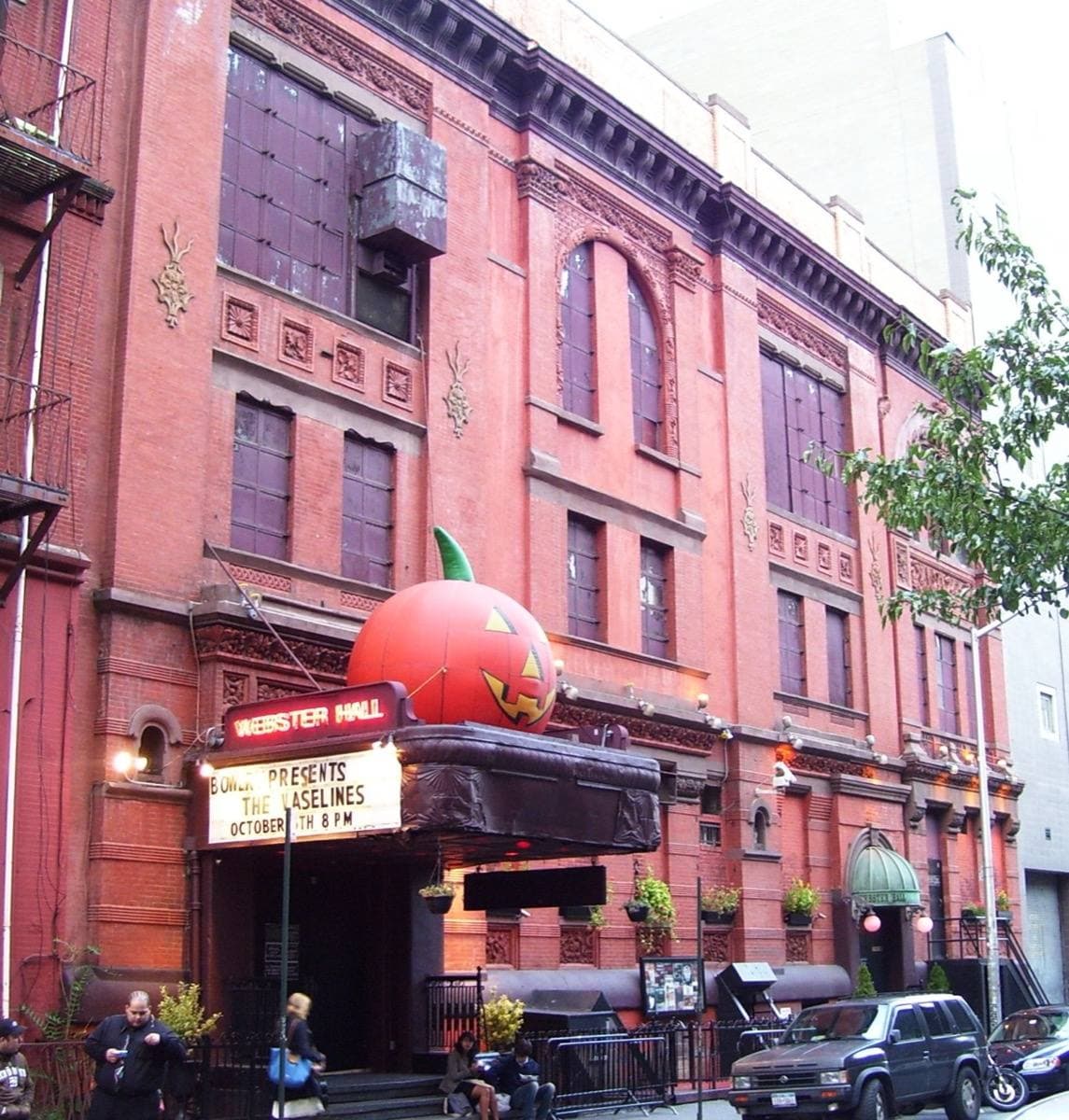 A red-brick hall with terracotta ornament and a marquee over the entrance