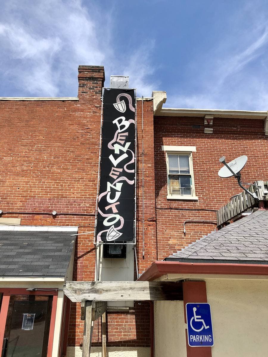 A vertical restaurant sign reading Pompilio’s on a brick corner building