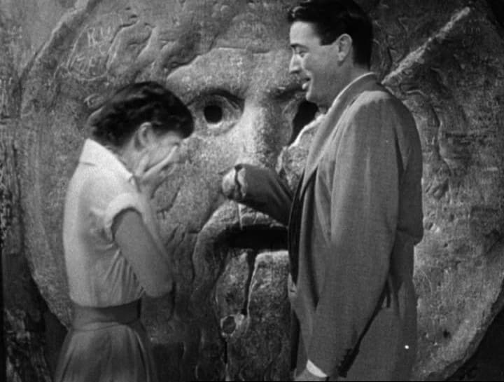 Audrey Hepburn and Gregory Peck beside the stone mask of the Bocca della Verità