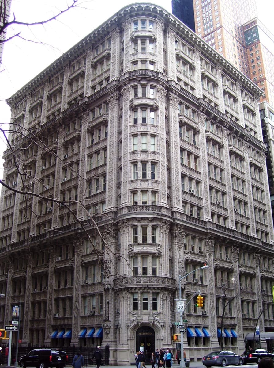 A terracotta-covered apartment building with ornate dragon and salamander carving