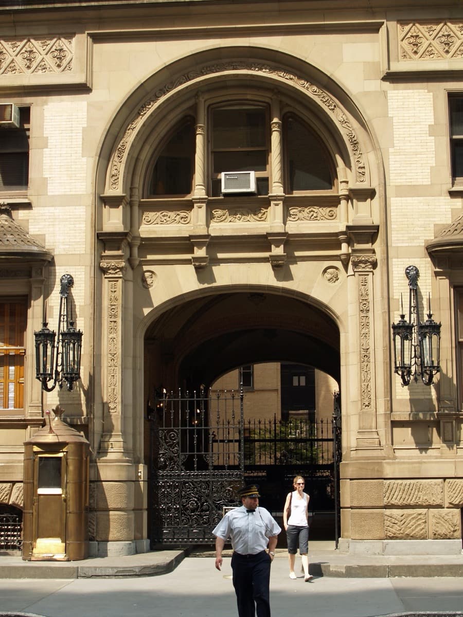 An arched carriage entrance in a dark masonry apartment building