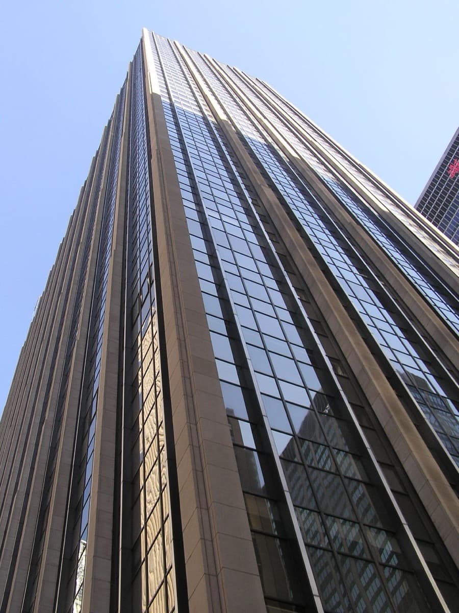 A tall modern office tower rising above a Manhattan street