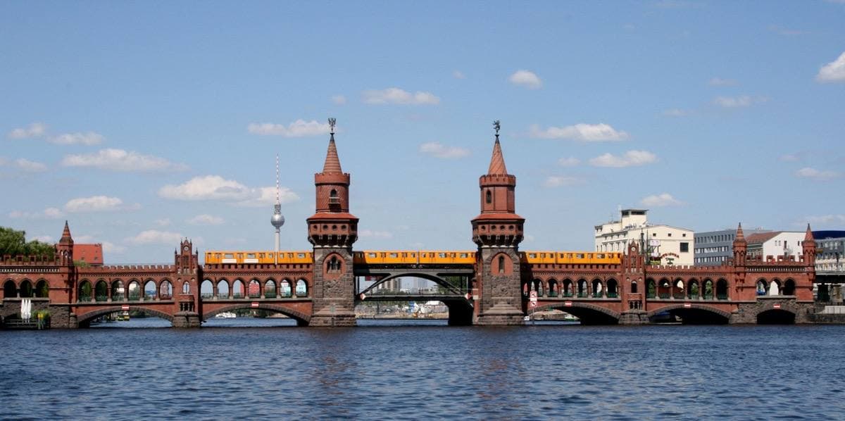 The red-brick Oberbaum Bridge across the Spree with its two towers and a yellow train on top