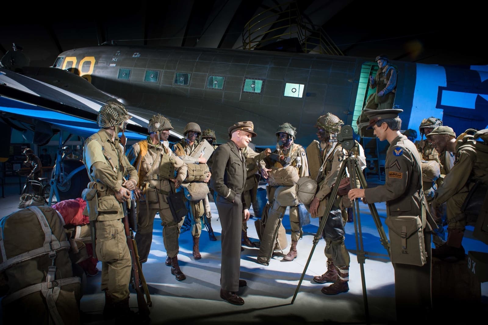 A wartime transport plane in a museum hall, with figures of paratroopers in front of it
