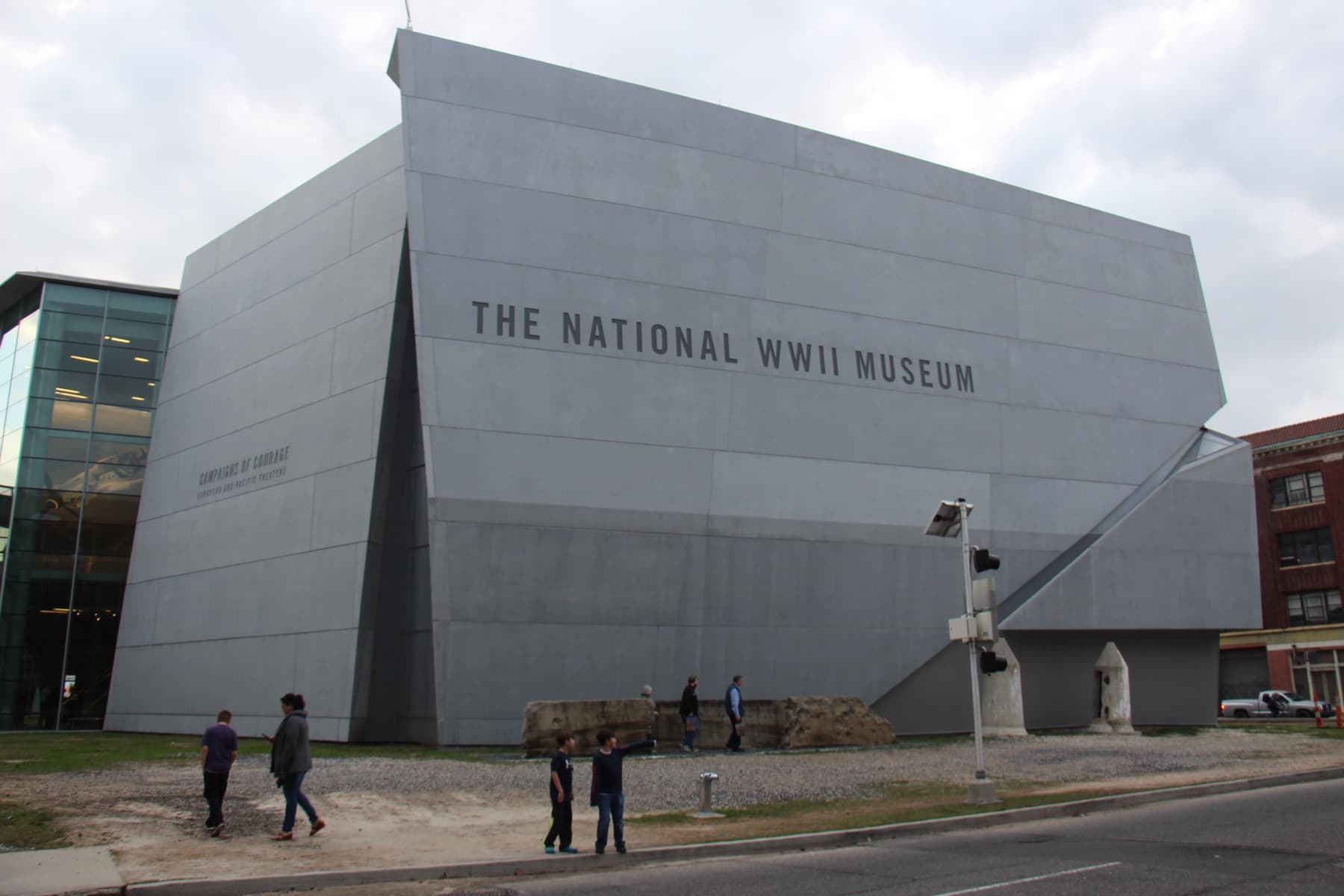 A large grey angular museum building with its name on the wall