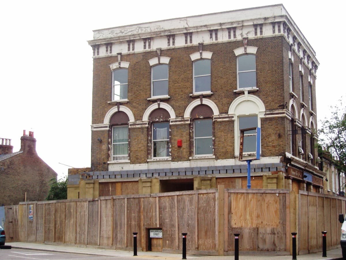 A three-storey Victorian corner pub with a hanging sign