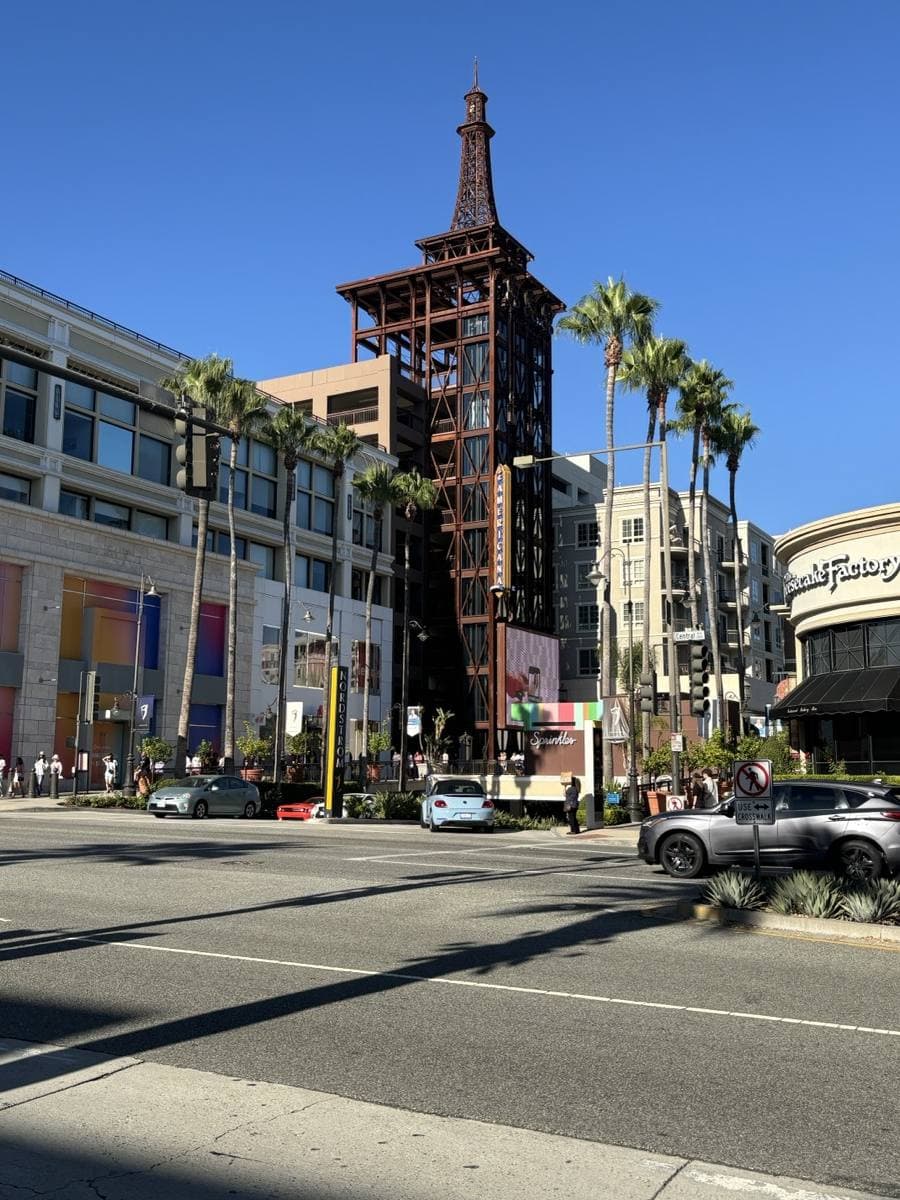 A busy downtown boulevard in Glendale with palm trees and a tall clock tower