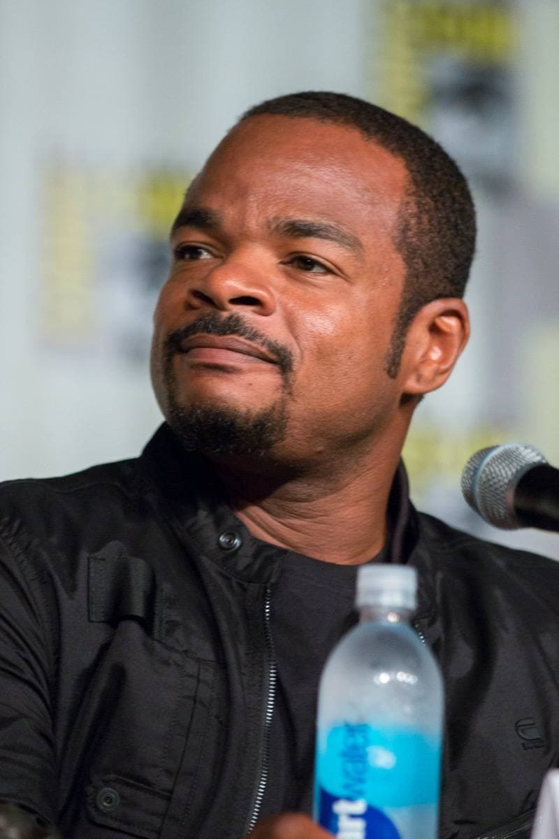 F. Gary Gray in a black jacket at a panel table, looking to one side