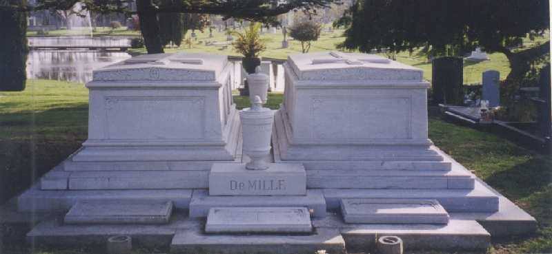 Two white marble tombs side by side on a lawn