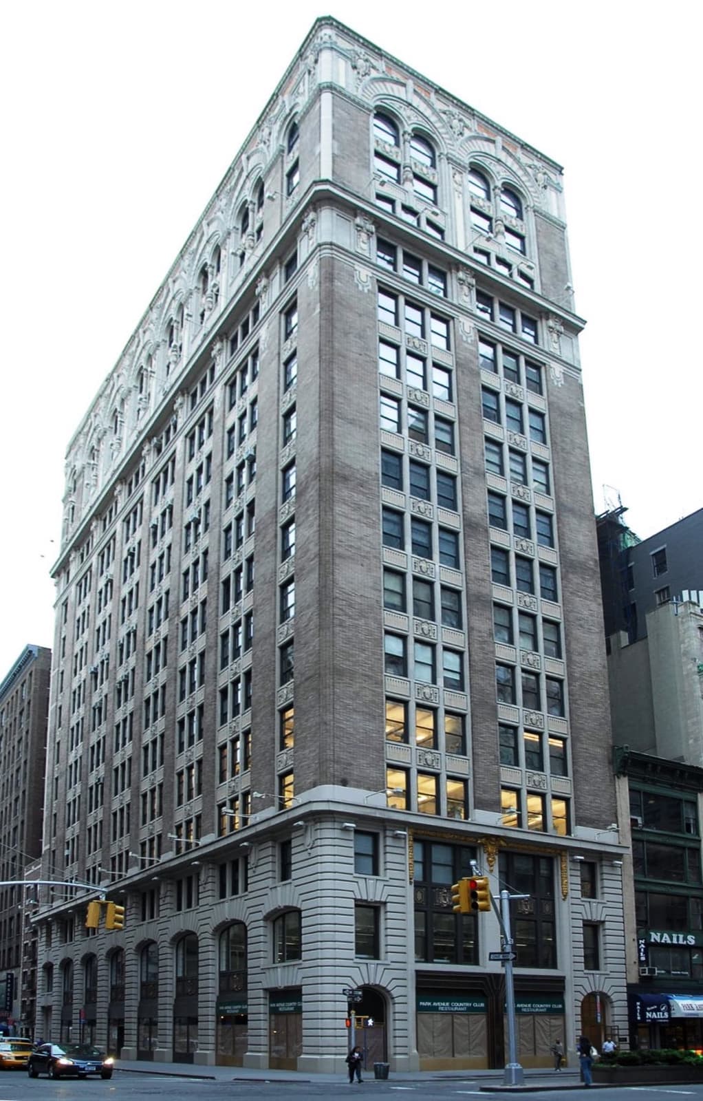 A tall pale stone office building on a corner of Park Avenue South
