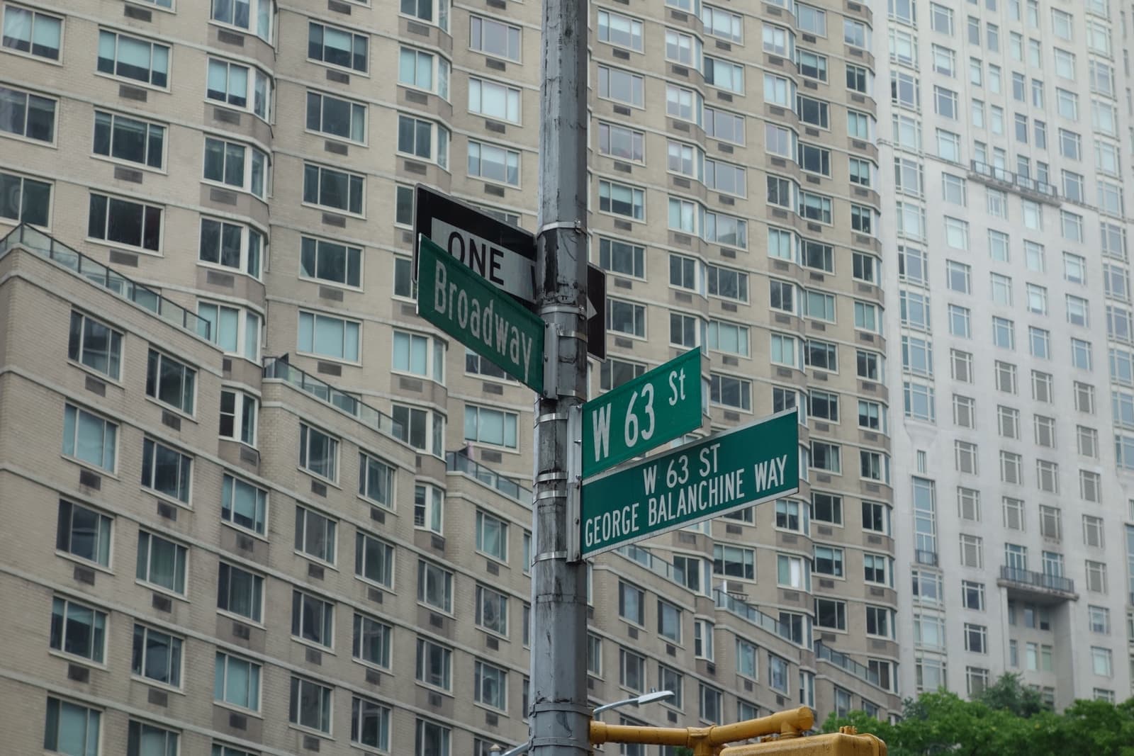 Street signs for West 63rd Street and Broadway with apartment towers behind