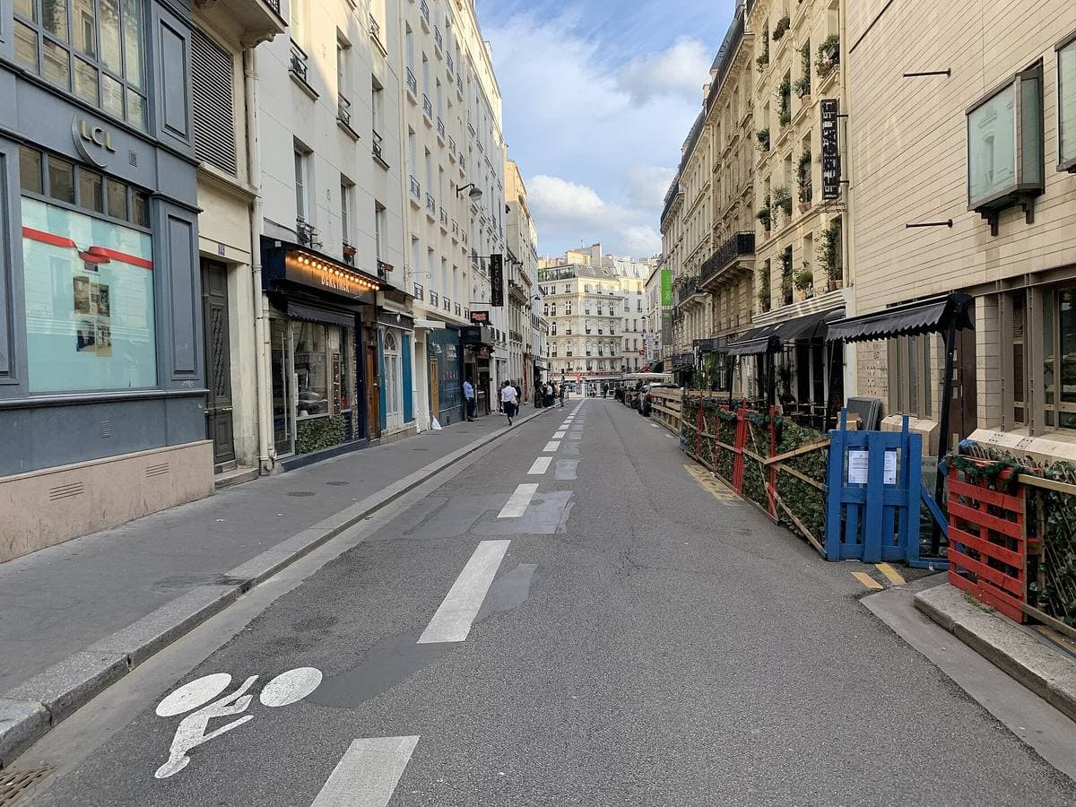 A narrow Paris street with parked scooters