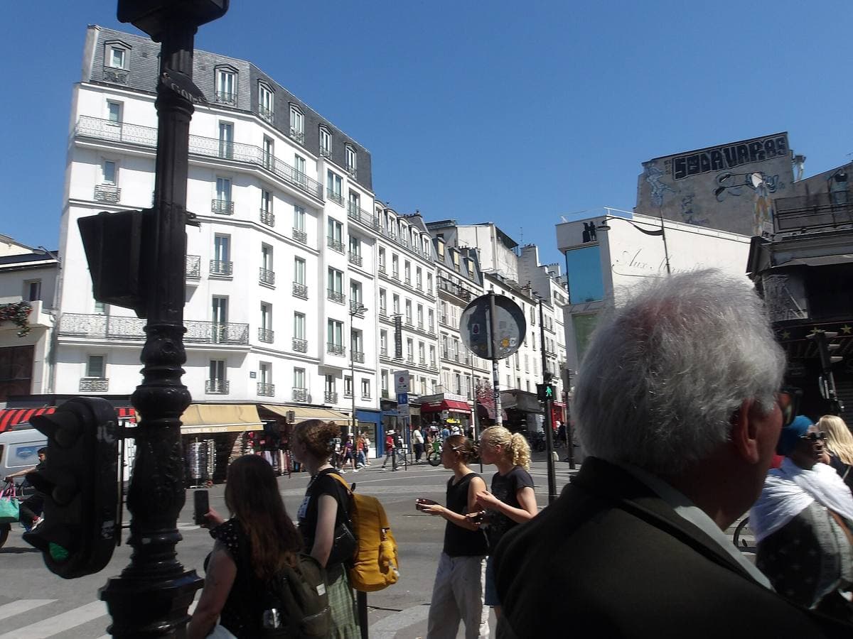 A street corner in Pigalle with shops, people and a lamp post