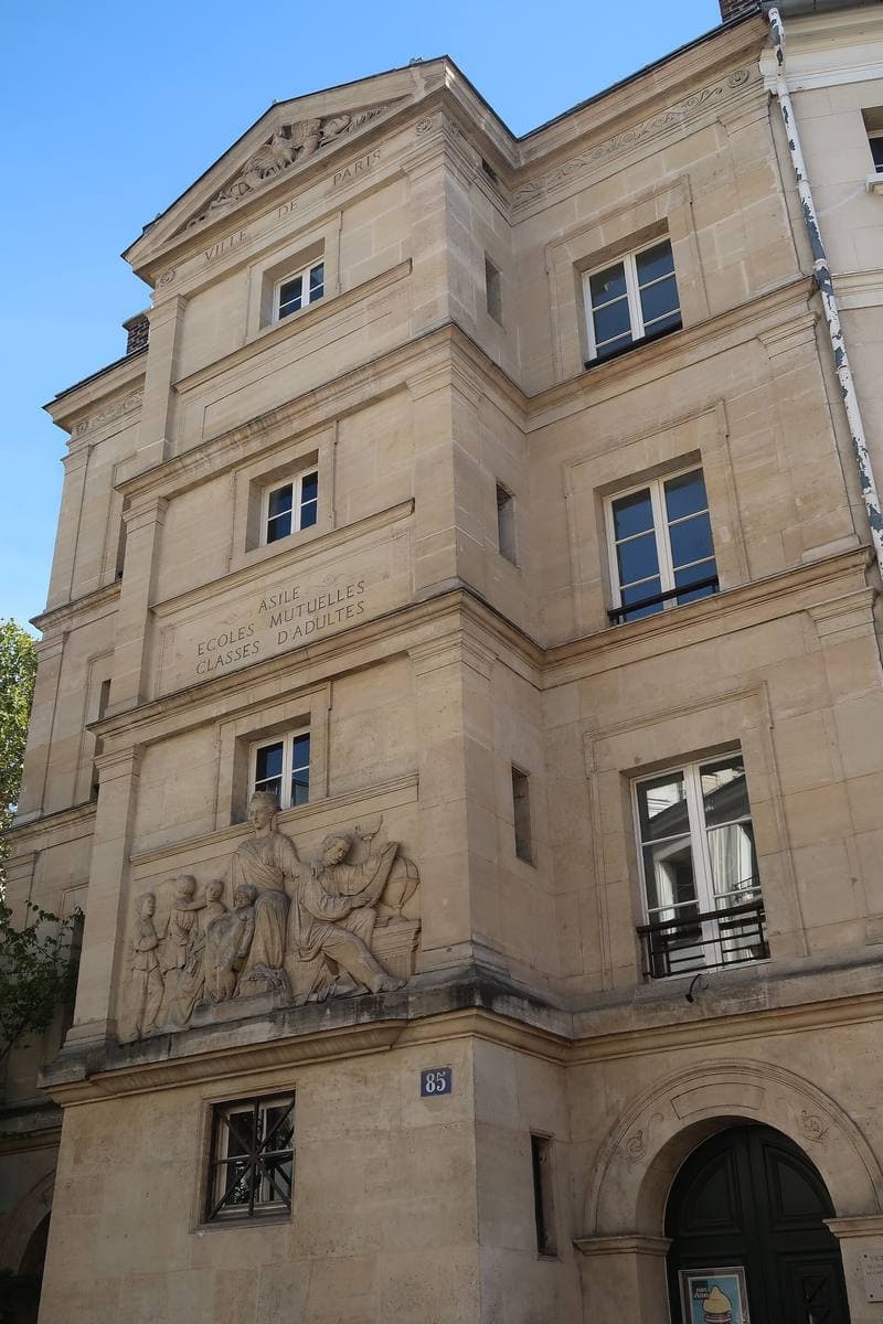 A tall stone building with a carved bas-relief across its corner