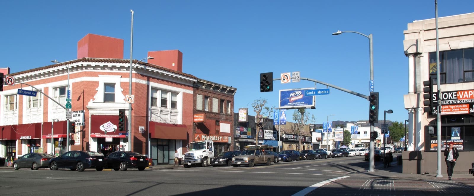 A busy junction on Santa Monica Boulevard with low shops
