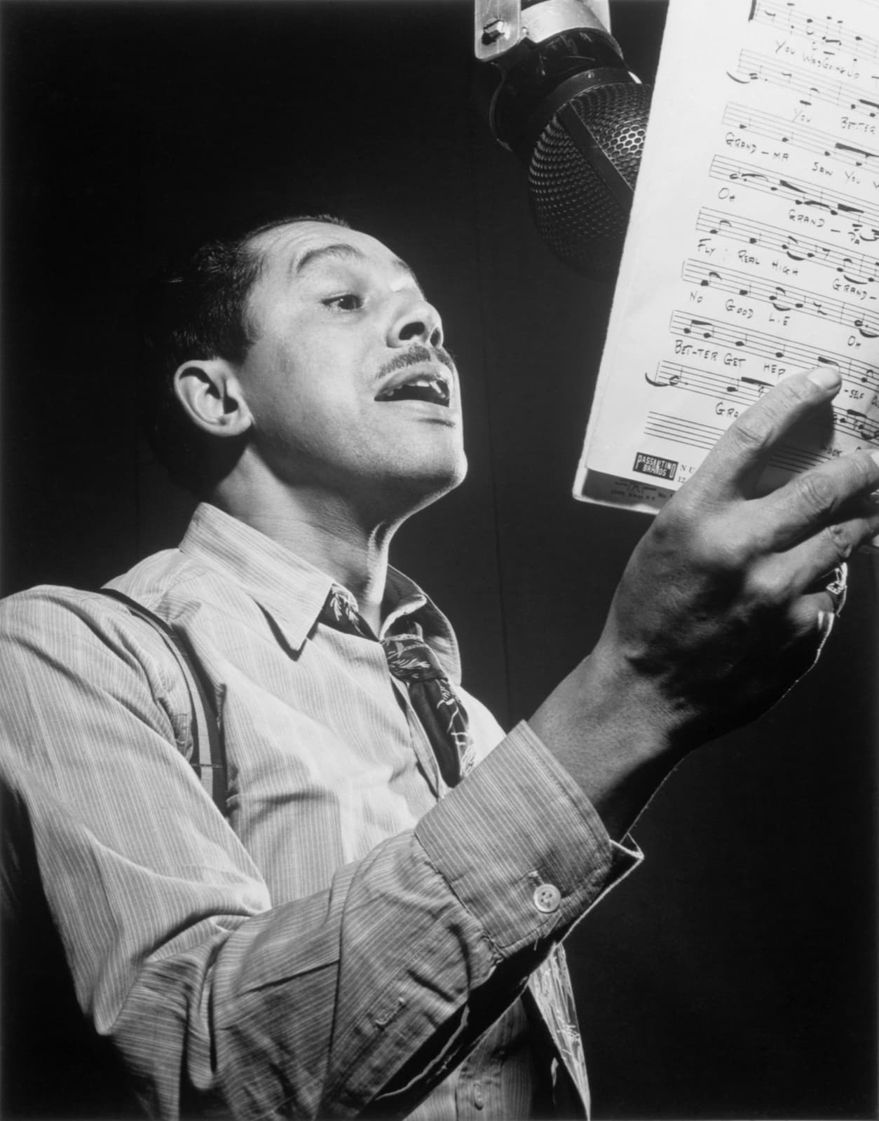 Cab Calloway in a white suit, laughing, in a black-and-white portrait