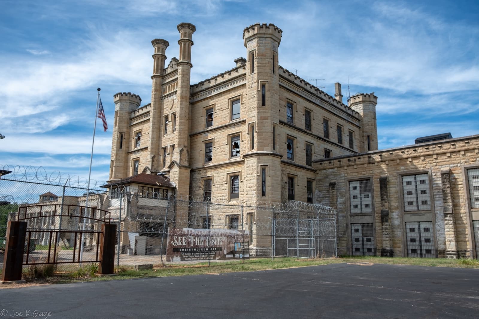 The limestone towers and walls of the Old Joliet Prison under a blue sky