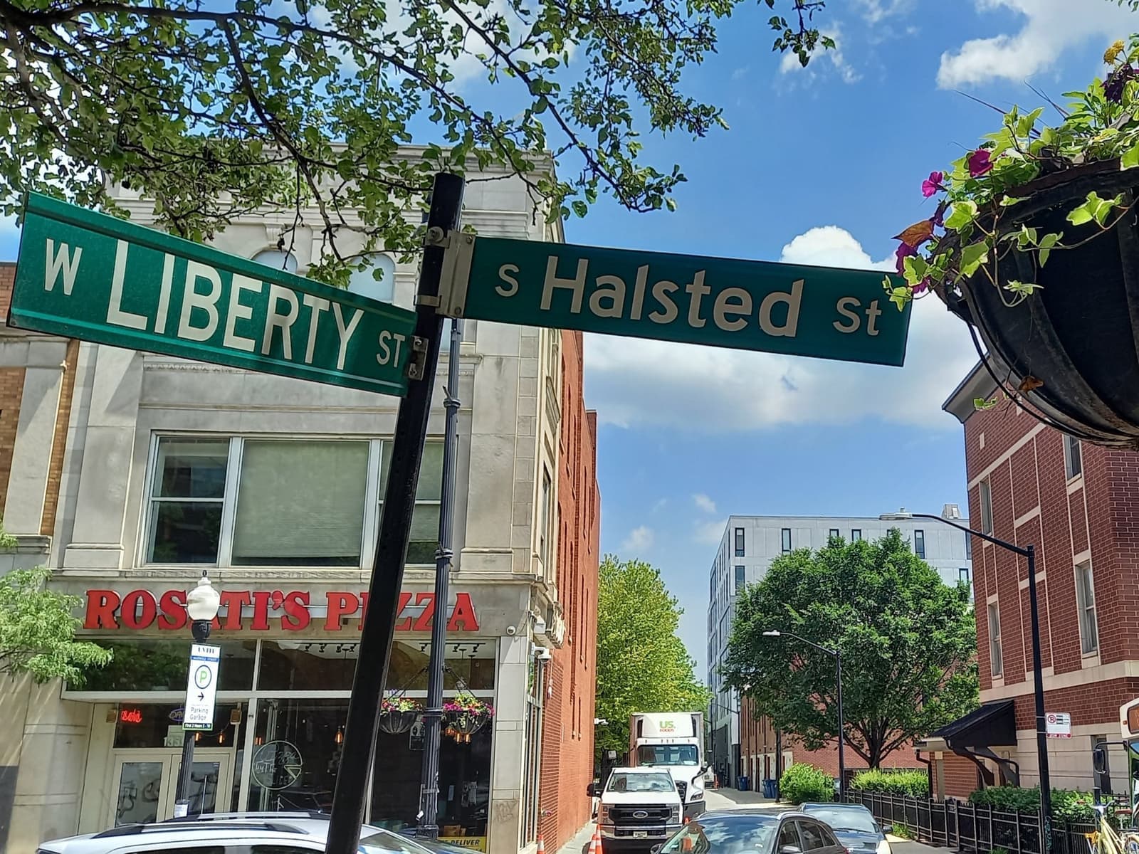 Street signs for Liberty Street and Halsted Street above a row of shops