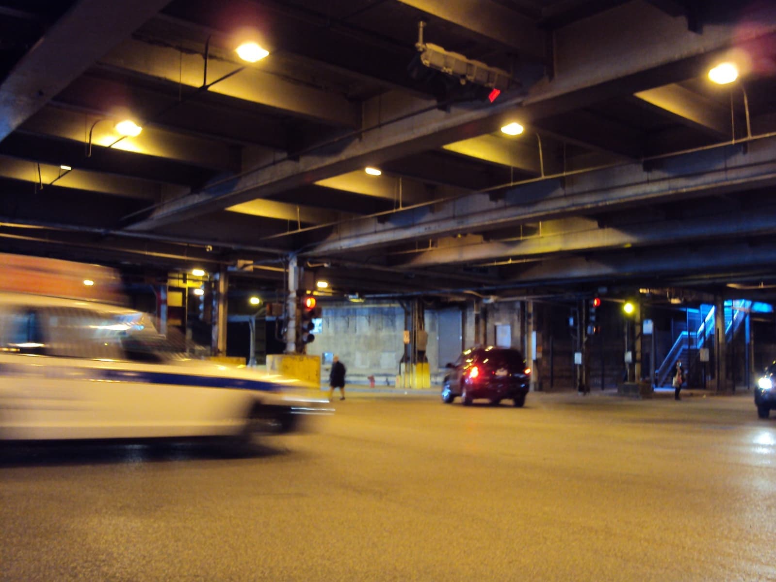 A car streaks under the yellow lights and steel beams of Lower Wacker Drive