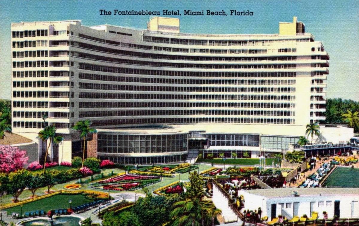 Colour postcard of the curved Fontainebleau hotel and its gardens