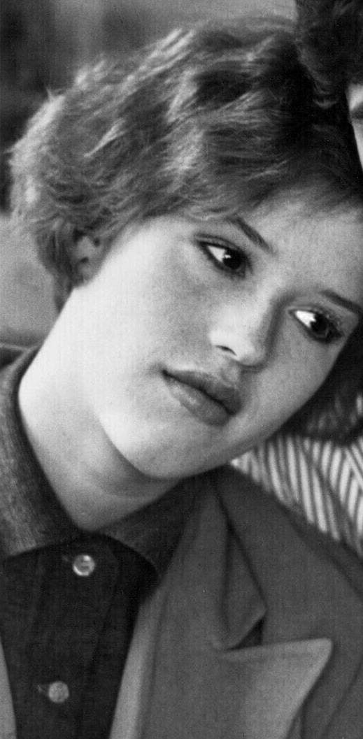 Molly Ringwald at 16, short dark-red hair, resting her head on a shoulder, black and white