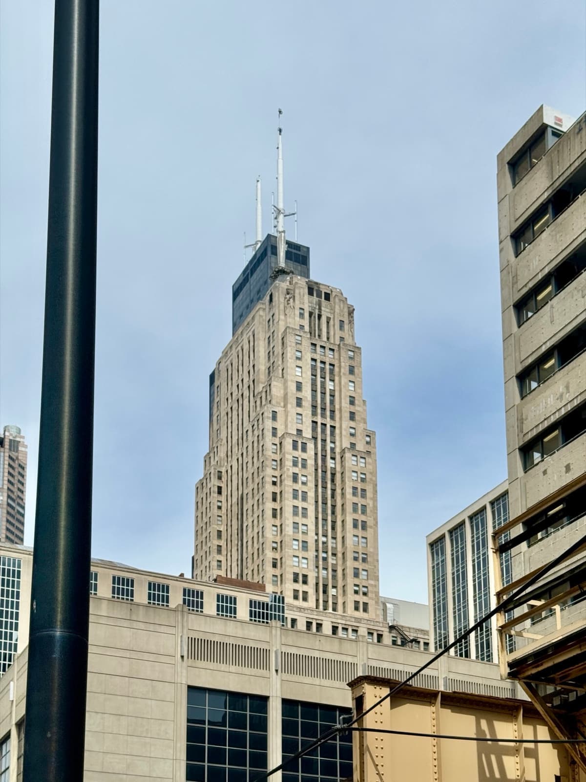 An Art Deco skyscraper with a pyramid roof closing the end of a street of stone banks