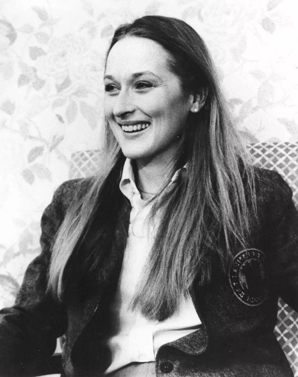 Meryl Streep smiling, long fair hair, in a black-and-white portrait