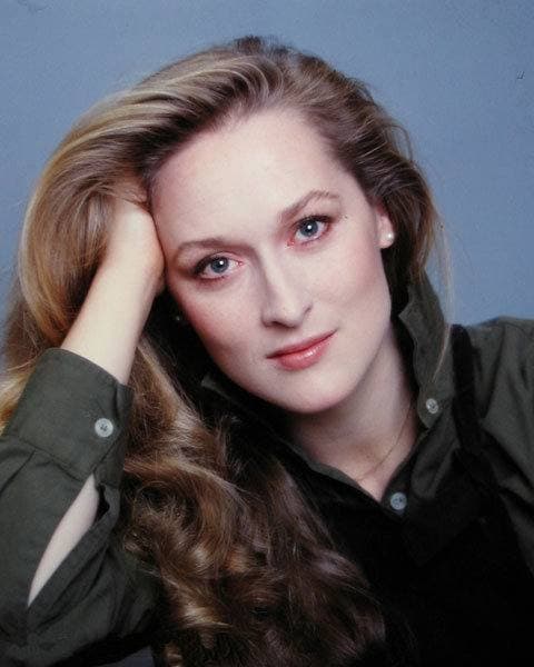 Meryl Streep resting her head on her hand, long wavy hair, in colour