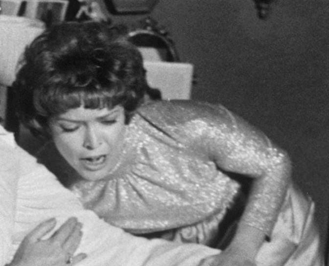Ellen Burstyn in 1973, short dark hair and a sequinned dress, leaning forward