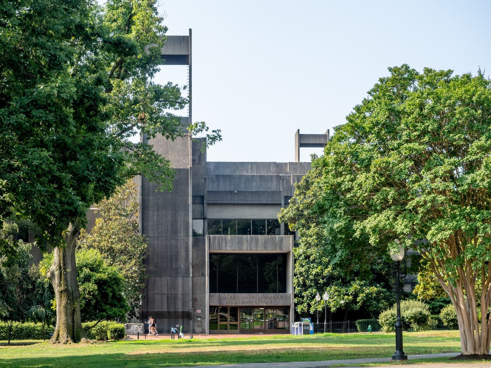 A concrete library building with deep-set windows and broad front steps