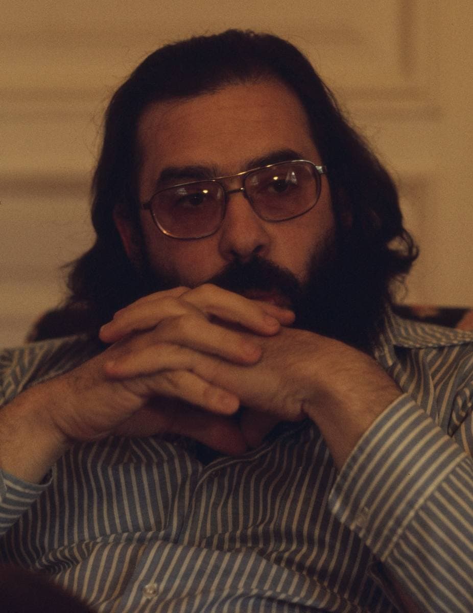Francis Ford Coppola, bearded, in glasses, his hands clasped under his chin