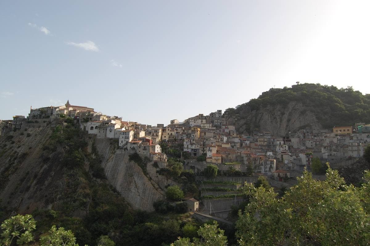 A hill town of pale houses spread along a ridge above a green valley