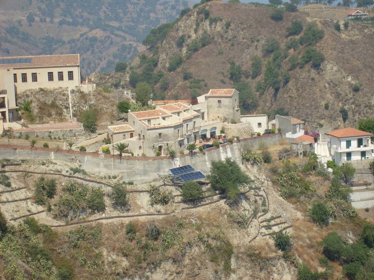 Old stone houses climbing a hillside in the San Rocco quarter of Savoca
