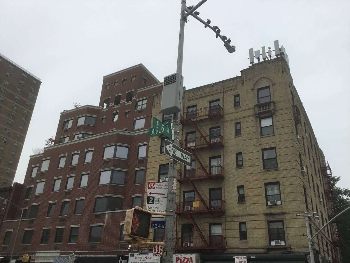 Brick tenement buildings with fire escapes on the corner of Avenue A and East 6th Street