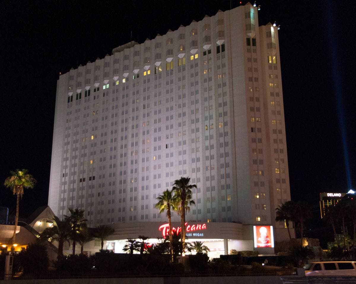 The lit towers of the Tropicana hotel against a night sky