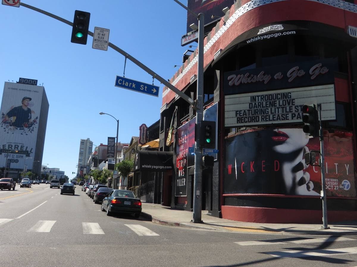 A low red club building with a marquee on the corner of Sunset Boulevard