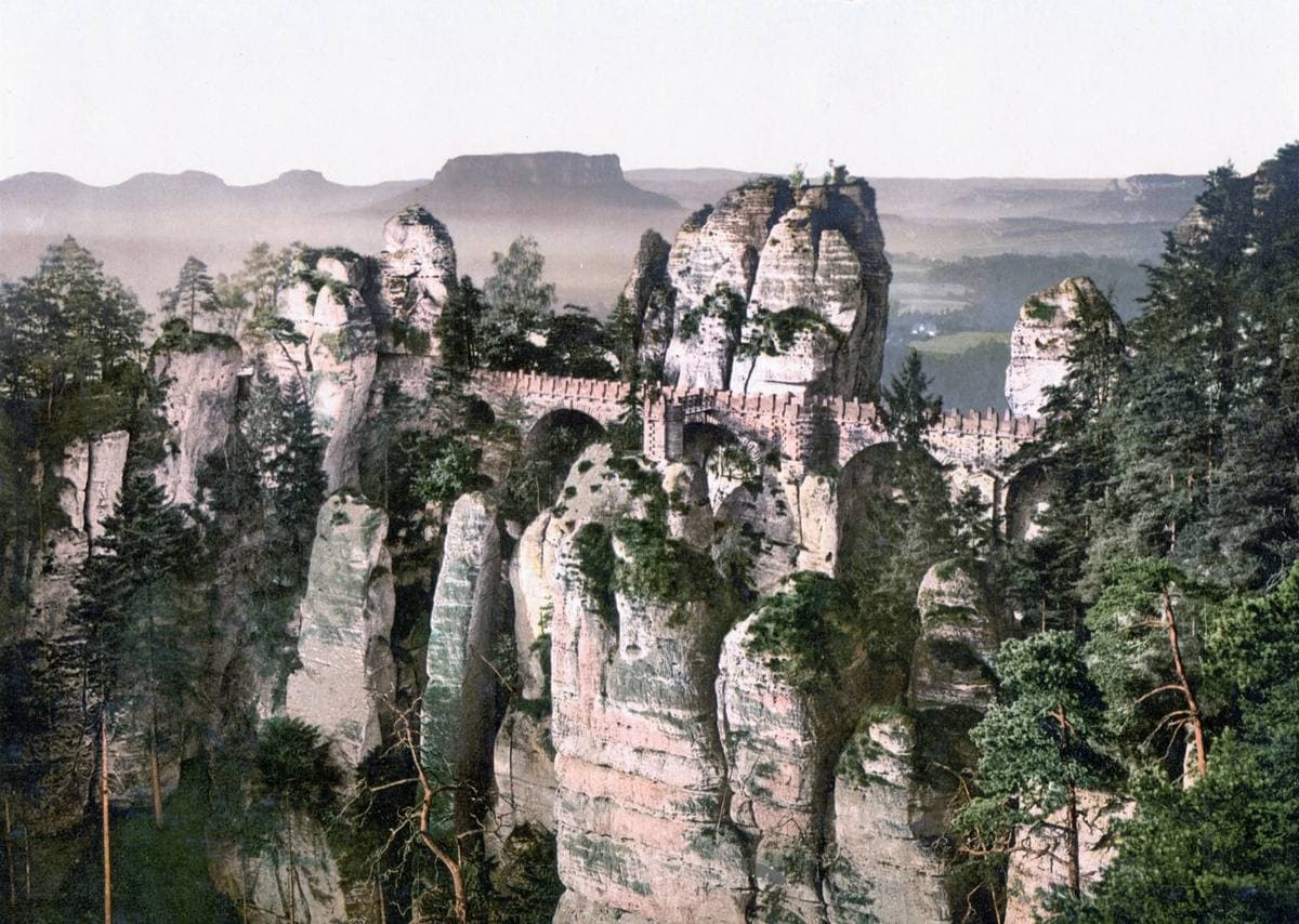 A hand-coloured view of sandstone pinnacles and an arched bridge