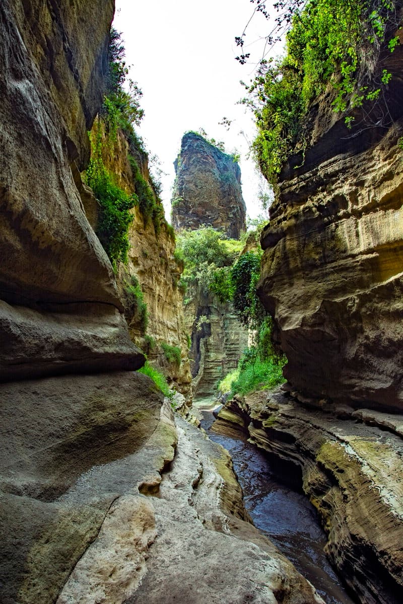 Sheer reddish gorge walls with a path below