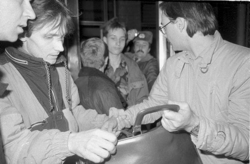 People crowding round papers inside the Stasi headquarters in January 1990