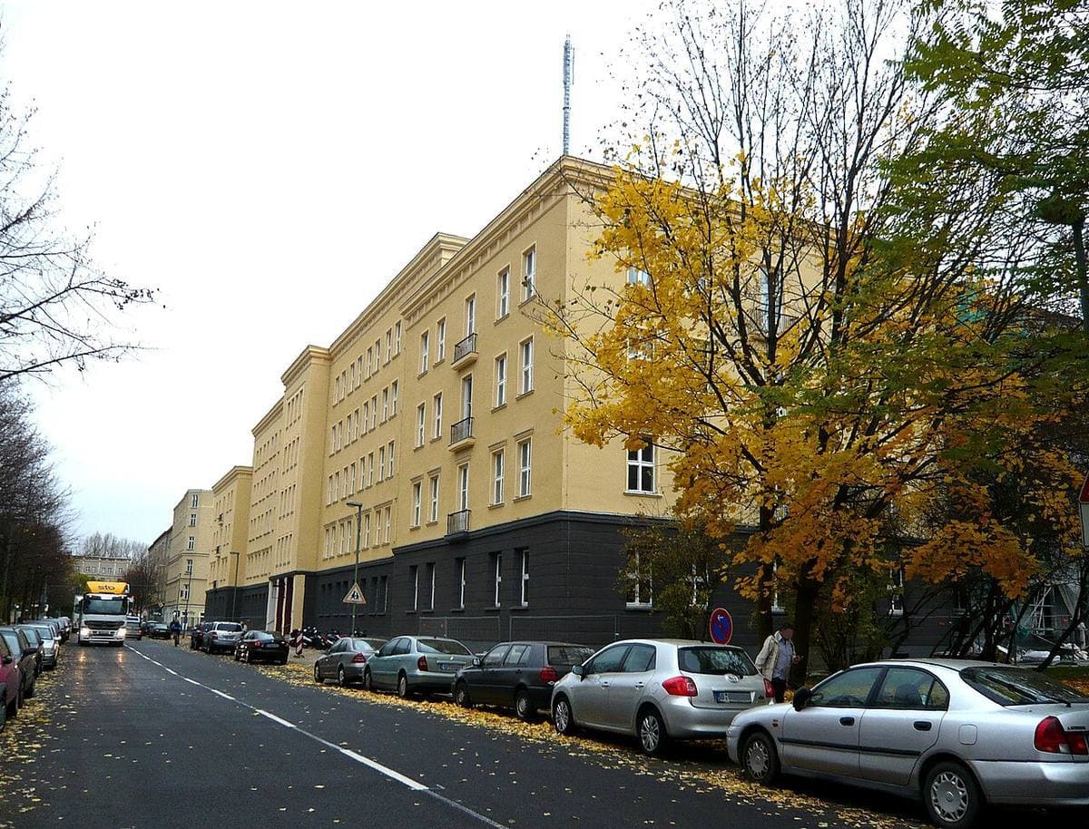 A Friedrichshain street of yellow blocks and parked cars in autumn
