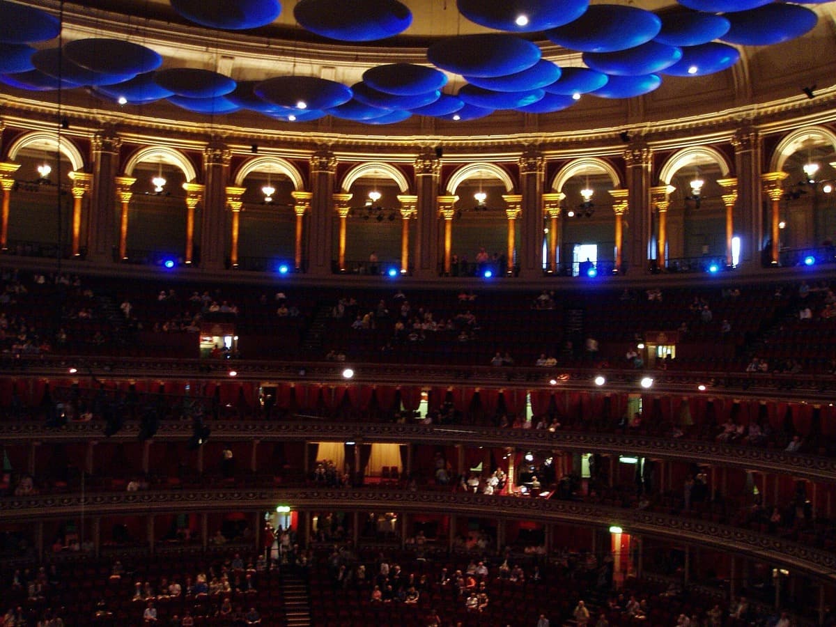 Tiers of red seating and boxes rising round the oval Royal Albert Hall auditorium