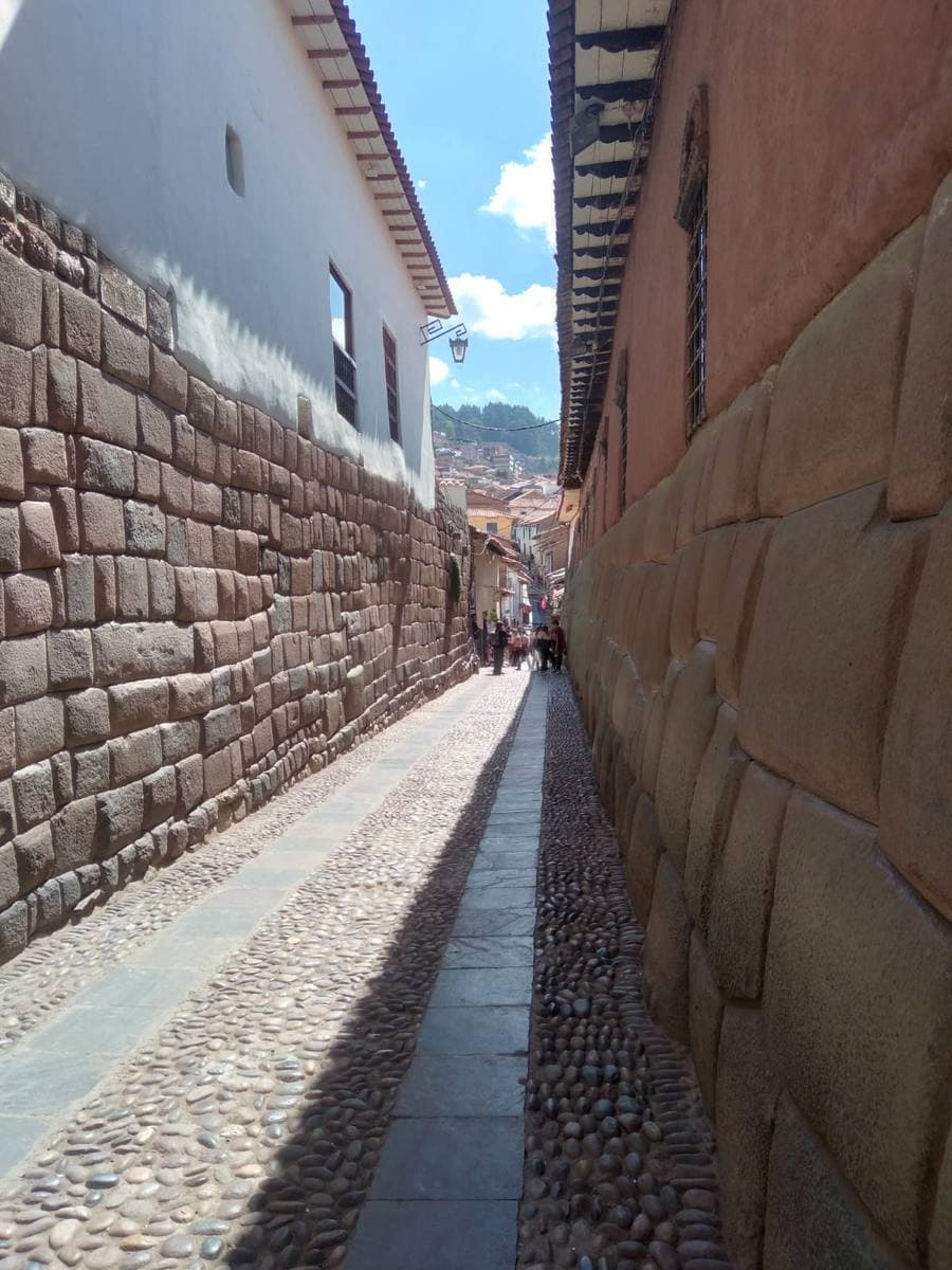 A narrow stone lane beside a wall of huge fitted Inca stones
